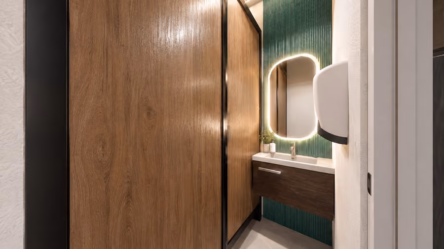Interior rendering of a clinic bathroom with a green tile wall and a backlit mirror